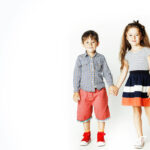 120783167-little-cute-boy-and-girl-hugging-playing-on-white-background-happy-smiling-family-lifestyle-people